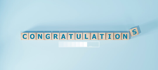 Word ‘Congratulations’ spelled out in blue text on wooden blocks.