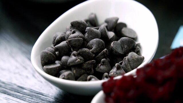 Nice close up shot of semi-sweet chocolate chips with red beet pulp in the foreground