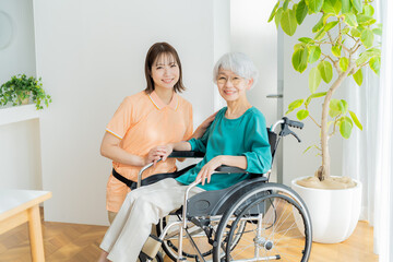 車椅子に乗った女性をサポートする介護士