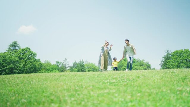 緑の丘で遊びまわる家族