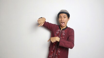 shocked asian muslim man gesturing pointing down