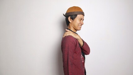 Asian Muslim man gesturing with shoulder pain