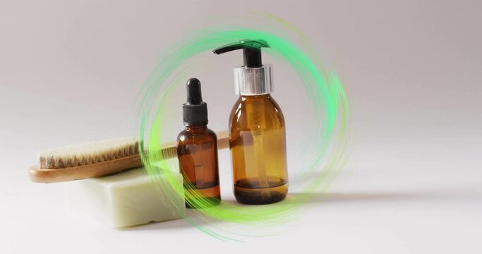 Animation of green ring over soap, brush, self care and beauty products on beige background