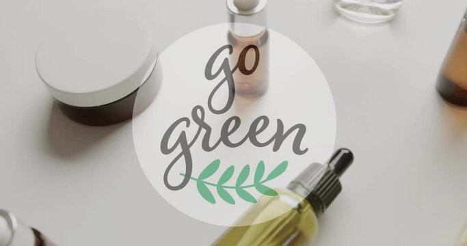 Animation of go green text and leaf logo over natural beauty creams and oils on white