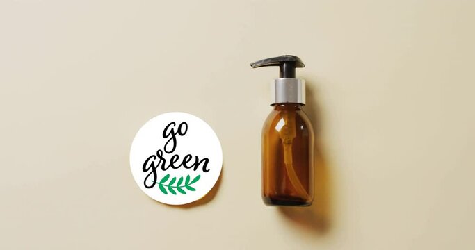 Animation of go green text and leaf logo over lemon slice and beauty oil pump bottle