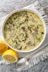Tasty Greek Easter soup with lamb offal, herbs, seasoned with egg and lemon sauce close-up in a...