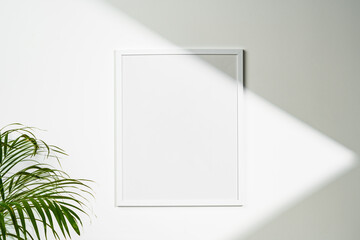 White wooden photo frame with plant leaves on white background