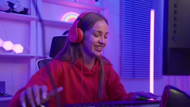 Caucasian e-sport woman gamer playing online video game on computer. 