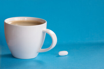 A single magnesium dietary supplement tablet close to a cup of morning coffee, replenishing...