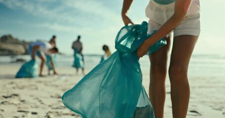 Beach, recycle and volunteer with plastic bottle for cleaning, pollution and eco friendly environment. Dirt, waste and people with trash bags for teamwork, charity and community service on earth day