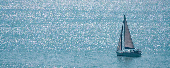 White  sailboat on the blue sea