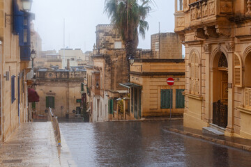 Narrow street of ancient city Rabat with traditional maltese houses built of limestone, Victoria,...