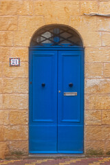 Blue door in house on the street of ancient city Rabat with traditional maltese houses built of limestone, Victoria, Malta
