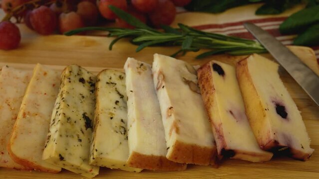 Different types of hard cheeses with additives on a wooden board on the table. Panorama. Cheeses in the gourmet's diet.