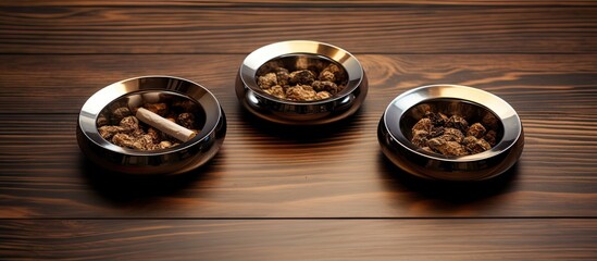 Fototapeta premium Three Metal Bowls Filled with Cigarette Butts, Concept of Smoking Addiction and Unhealthy Habits