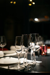 Tableware and Glasses, fork and knife served for dinner in restaurant with modern interior.