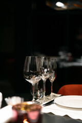 Table settings for fine dining with glassware, dark blurred background. For events, weddings, birthdays and celebrations.