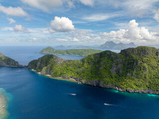 Matinloc Island with boat over the blue sea. Blue sky clouds. El Nido, Philippines.