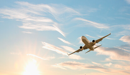 White passenger airplane flying in the sky amazing clouds in the background - Travel by air...