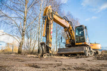 Fototapeta na wymiar yellow excavator on a sandy construction site