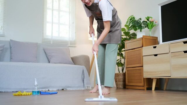 housewives use power-saving tools to clean the house to make the housework faster and cleaner, Asian woman wears rubber gloves while cleaning various furniture in her home with cleaning solution.