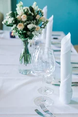 Fotobehang Eetkamer Table set for an event party or wedding reception. Glasses and cutlery on the table. Still life floral arrangement  © O G