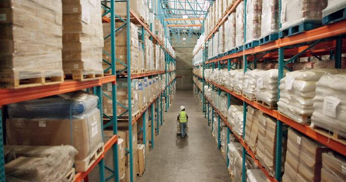 Warehouse, shipping and person walking in a distribution, freight and supply chain company. Worker, contractor and back with stock, factory and export business with employee working with storage