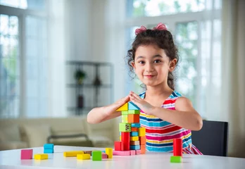 Fotobehang Lego Indian asian child preschooler girl playing wooden toys at home or kindergarten  © StockImageFactory