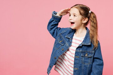 Little child cute kid girl 7-8 years old wears denim shirt have fun hold hand at forehead look far...