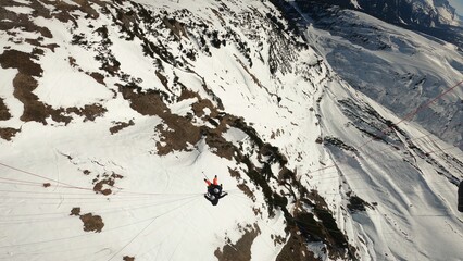 Tandem paraglider in the air on snow background. Paragliding in winter