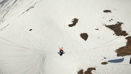Tandem paraglider in the air on snow background. Paragliding in winter