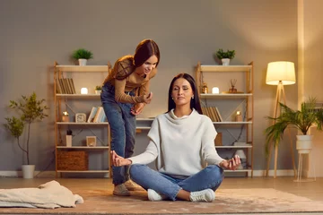 Foto op Plexiglas Woman mother sitting on floor doing yoga exercise in lotus pose meditating at home practicing self control ignoring her angry teenage daughter shouting at her. Family generation conflict concept. © Studio Romantic