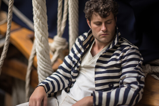 marin breton homme, habill&eacute; avec la traditionnelle marini&egrave;re &agrave; rayures bleues et blanches sur un vieux gr&eacute;ement breton, cotre, voilier ancien.
