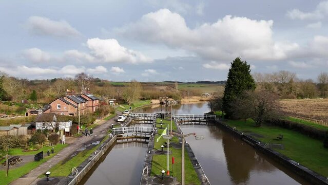 Shot of Dutton Locks in Cheshire, showing the river, small bridges, and buildings next to the bridge