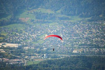 Red Paraglider Soaring Above the Urban Skyline