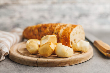 Smoked mini scamorza cheese. Traditional italian cheese on cutting board on kitchen table.
