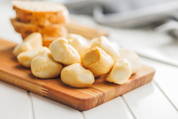 Smoked mini scamorza cheese. Traditional italian cheese on cutting board on white table.