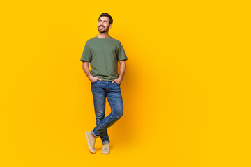Fototapeta na wymiar Full body photo of attractive young man hands pockets look empty space dressed stylish khaki clothes isolated on yellow color background