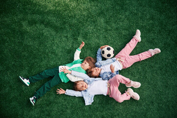 Top view. Lying down. Kids are having fun on the green soccer field together