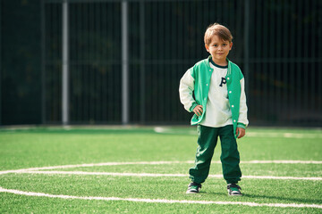 Full height photo of little boy on green field