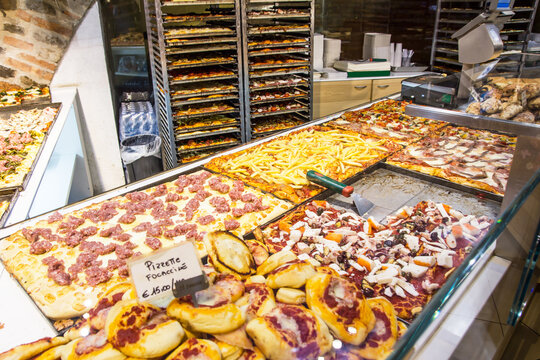 Pizza background. Italian pizza shop. Pizzeria market. Various types of pizza. Takeaway food.  Snack bar display. Pizza with meat and fries.