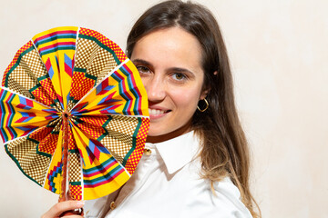 smiling woman with colorful african print fan