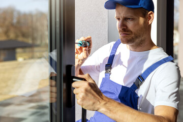 worker installing and adjusting aluminium frame sliding terrace doors