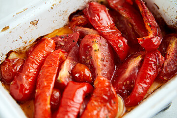 Baked tomatoes and bell peppers with garlic and herbs in ceramic form