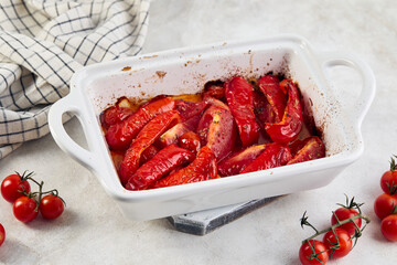 Baked tomatoes and bell peppers with garlic and herbs in ceramic form