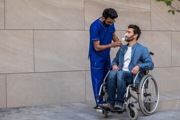 Young man in wheelchair wearing oxygen mask
