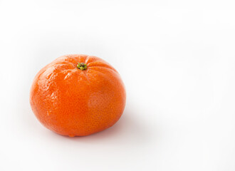 One whole, fresh, shiny, natural tangerine on a white background. Isolated