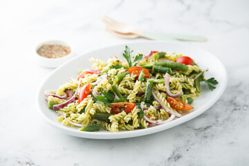 Healthy pasta salad with tomato, pesto sauce and green beans