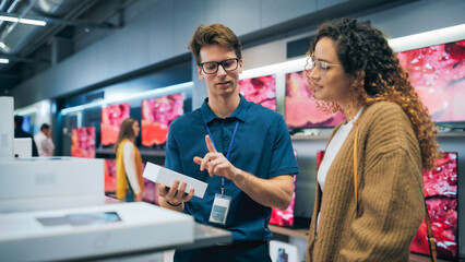 Portrait of Female Customer Seeking Advice from Retail Home Electronics Expert. Hispanic Girl...