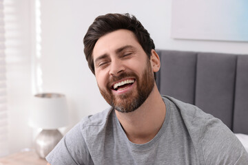 Portrait of handsome man laughing at home